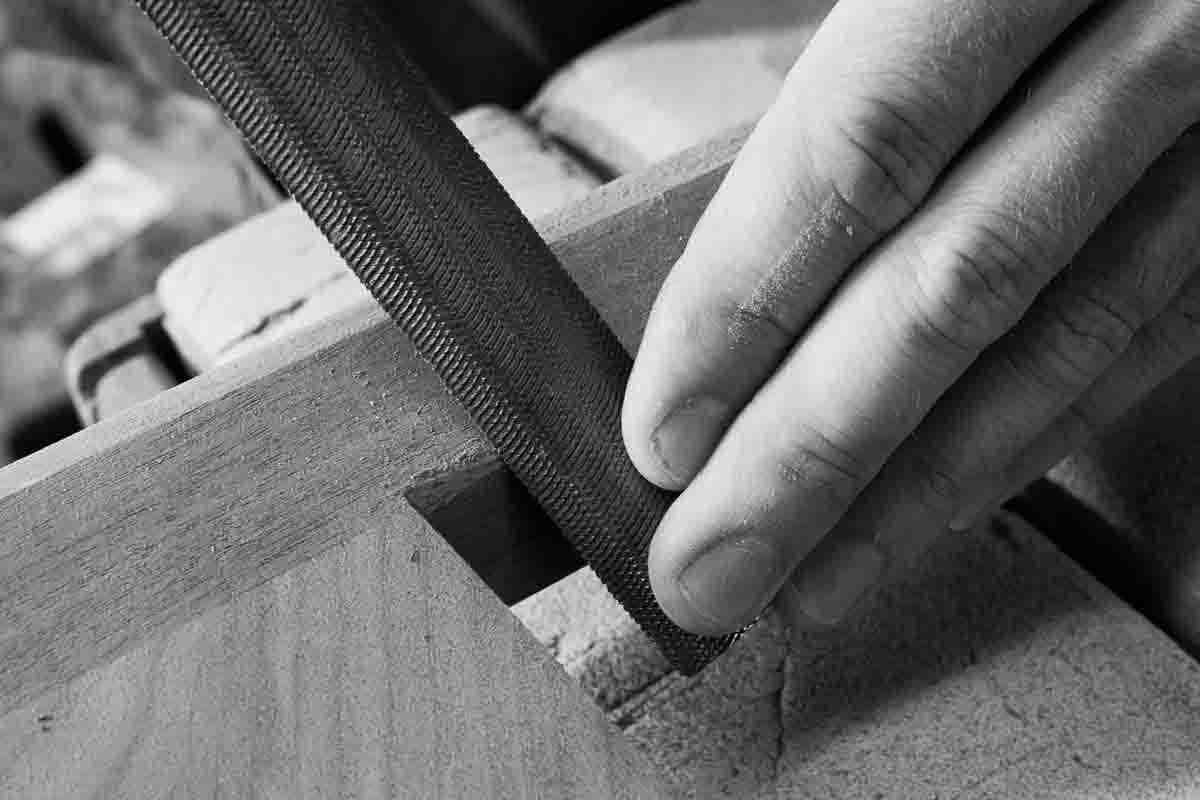 hand and rasp sculpting chair leg