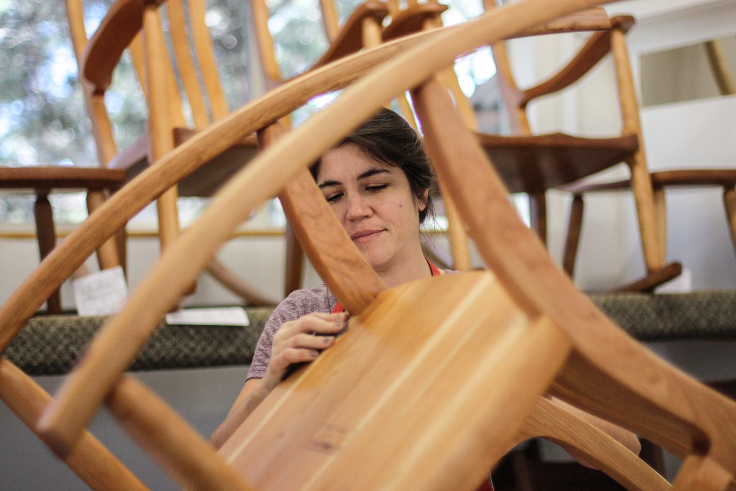 Audra sanding a rocking chair between coats