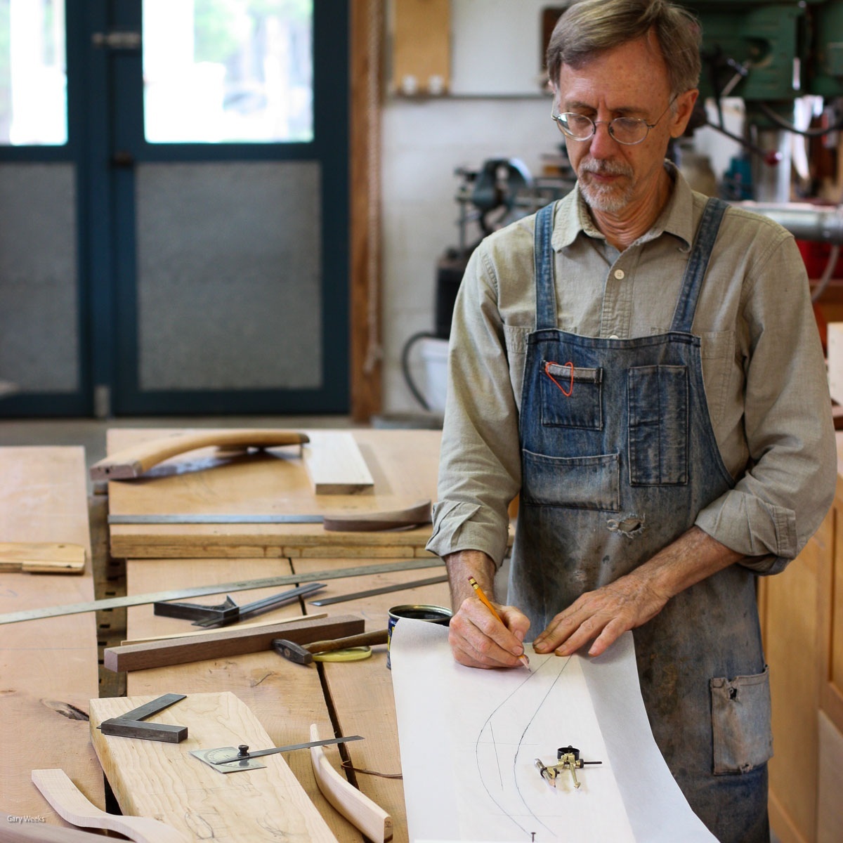hands drawing chair part at work bench