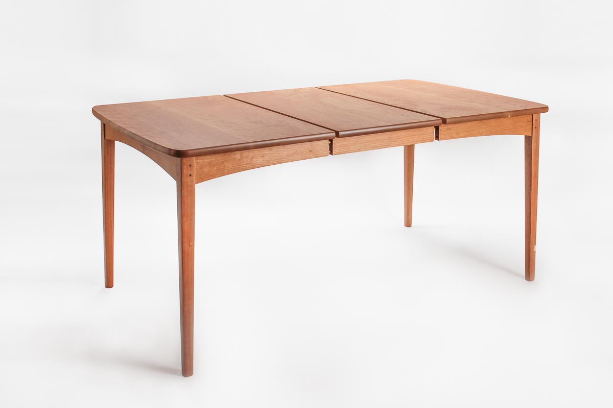 A cherry Phillips extension dining table, slightly open, with one leaf in place.