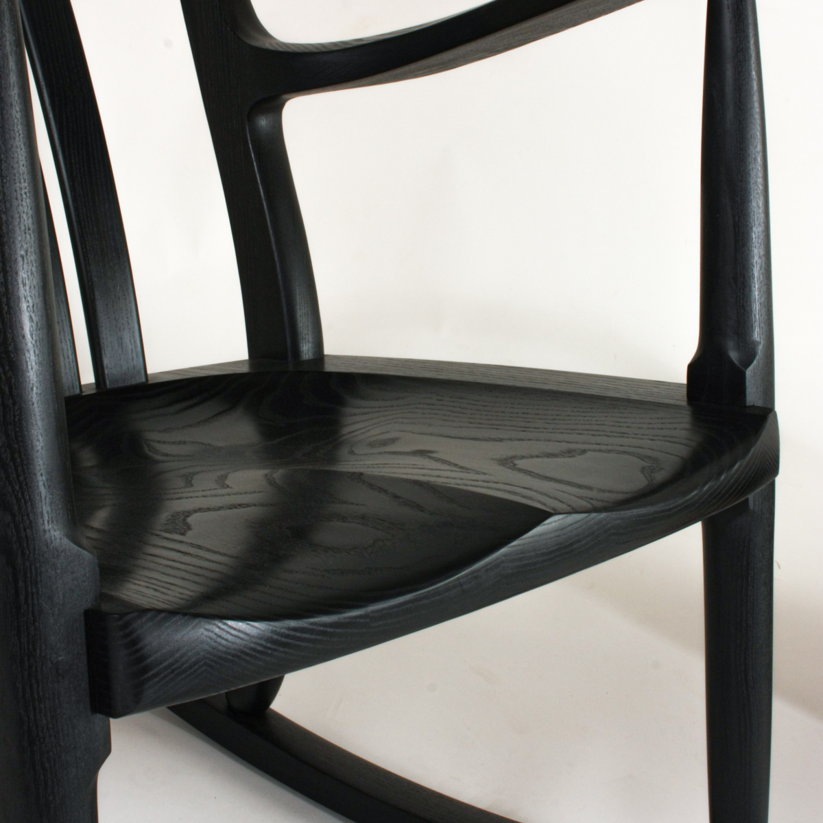 close up of an ebonized ash rocking chair seat showing the careful matching of wood grain figure.