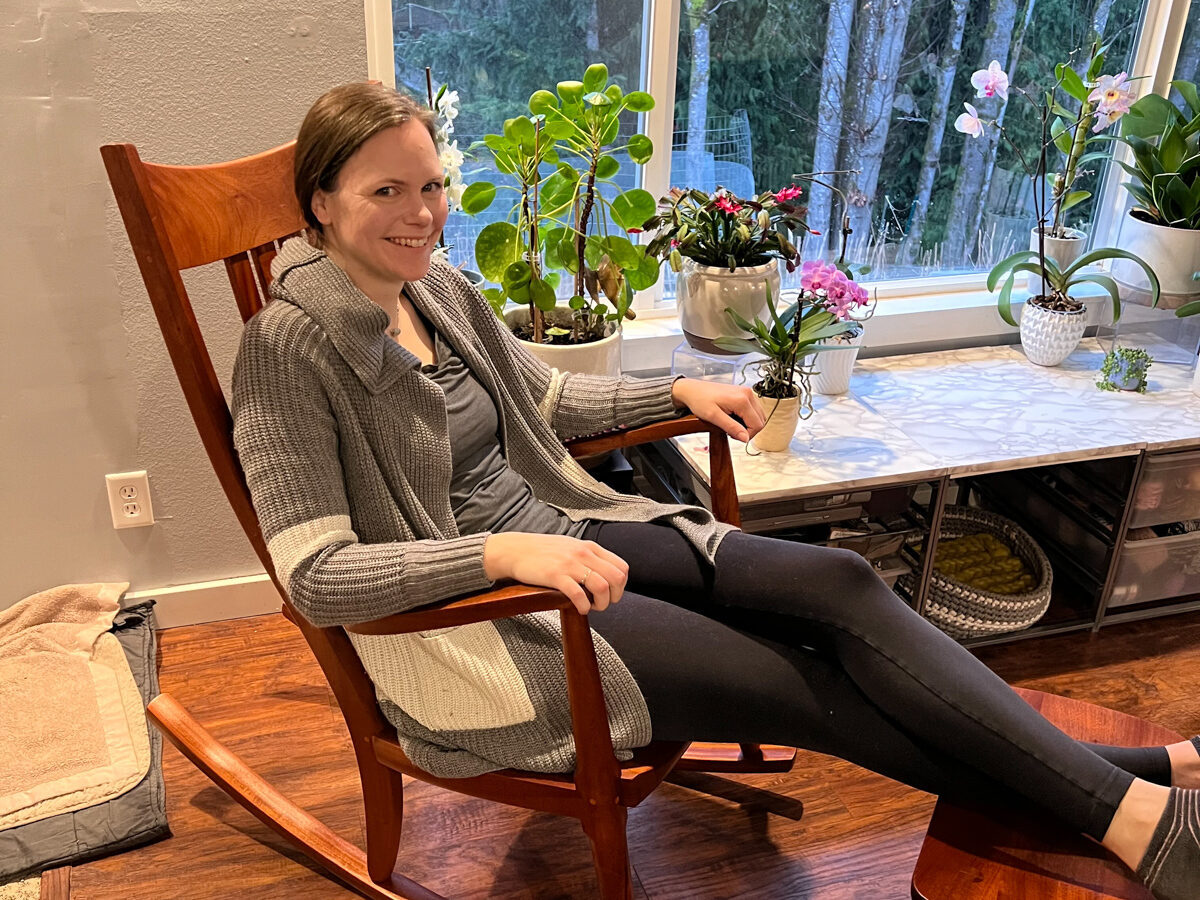 A woman in her just delivered Weeks Rocking Chair, smiling in comfort.