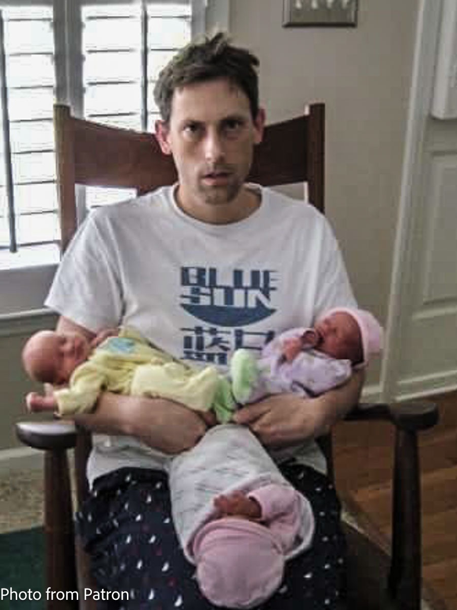 father and triplets in rocking chair
