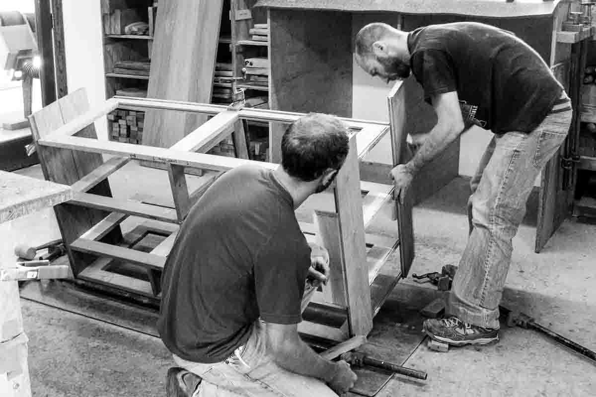Austin and Aaron assembling shelves to cabinet ends