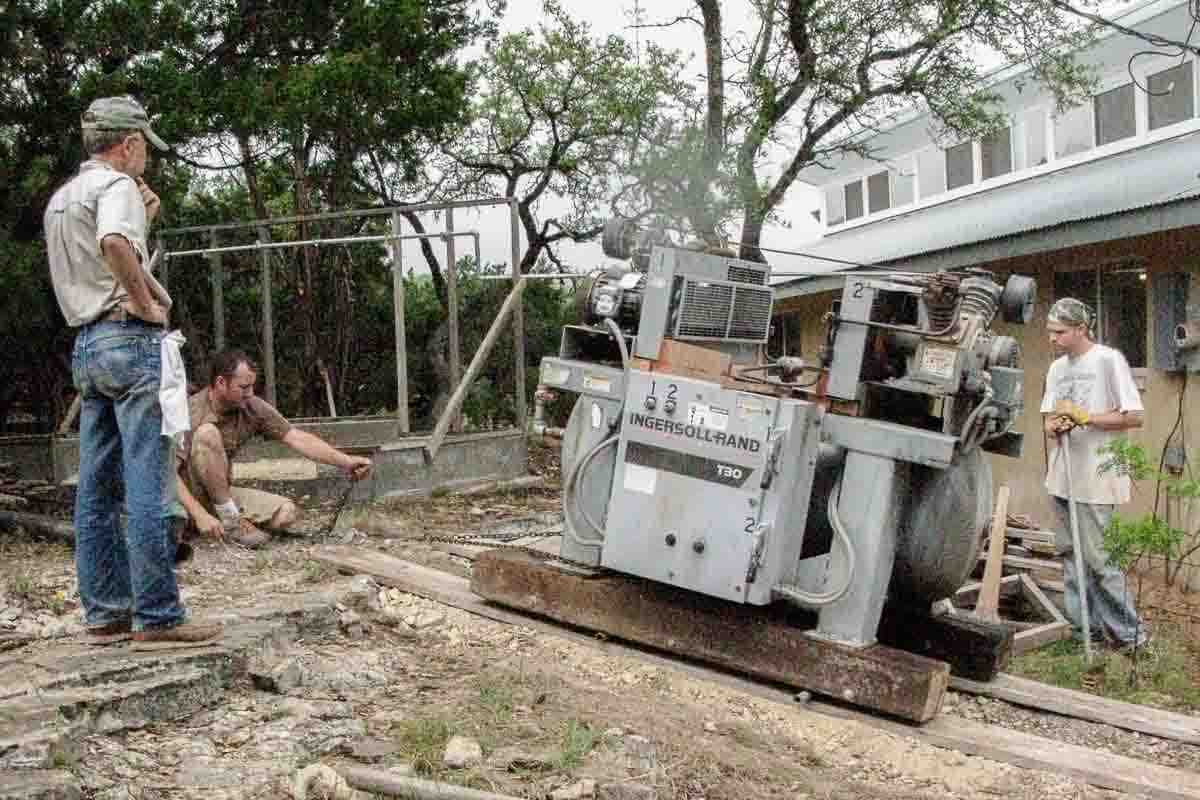 crew moving air compressor up hill by hand 3