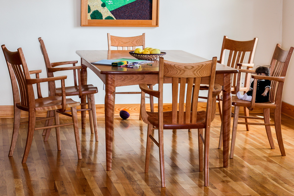 Paschall dining table and six Williams chairs in cherry in setting