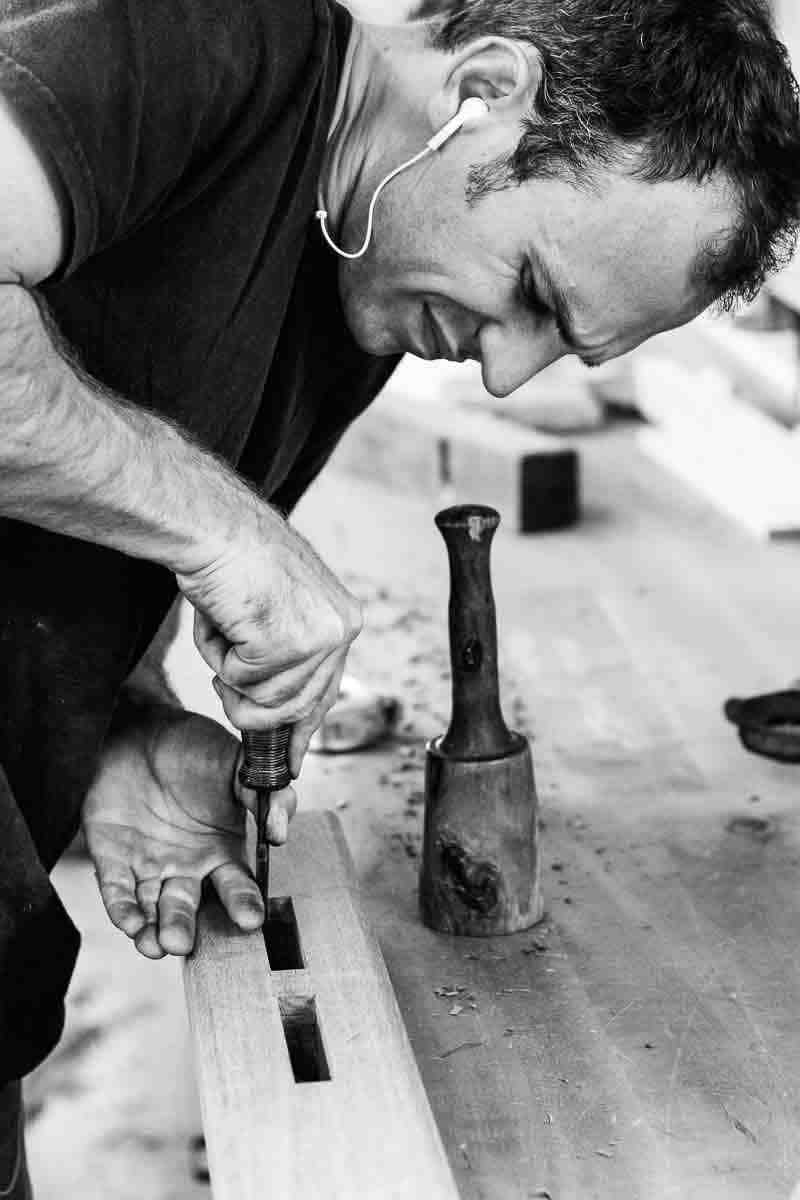 Austin cleaning a mortise in a trestle table upright